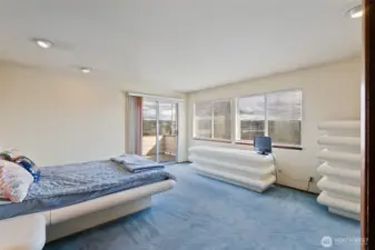 Large primary bedroom with original blue carpet.