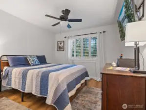 Bedroom 1 with ceiling fan is the first when heading down the hall