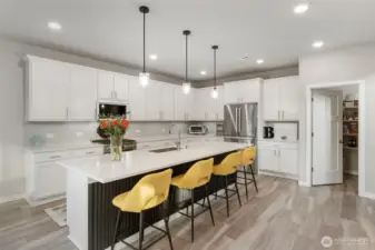 Timelessly beautiful white kitchen with quartz counters and Stainless Steel appliances. Gas range.