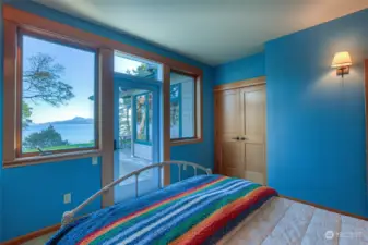 Main floor guest bedroom with door outside and water views.