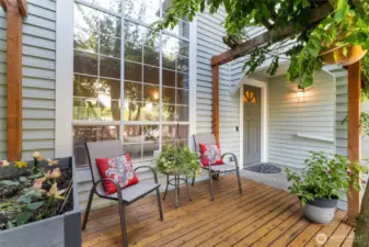 Front deck sitting area and covered entry with garden space.