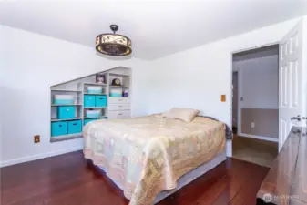 Primary bedroom has built in shelves for storing books, electronics, clothes, etc.