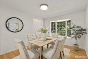 The formal dining room features stylish new lighting and offers flexible use—perfect as an elegant dining space or easily transformed into a main floor office or cozy sitting room to suit your lifestyle needs.
