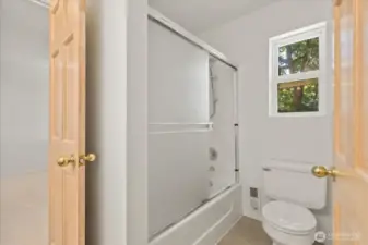 The second-floor bathroom includes a window that brings in natural light and fresh air, enhancing the bright and airy feel of the space.