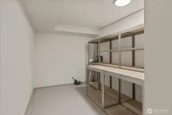 The lower level includes a storage area with built-in shelving—ideal for a wine room or extra storage—offering organized space to keep essentials neatly tucked away.