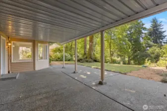 The covered patio offers year-round weather protection, creating a comfortable outdoor space for relaxing or entertaining while providing convenient entry to the lower leve