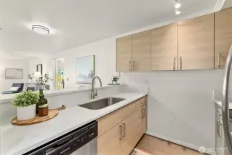 Open and bright kitchen features quartz countertops and stainless appliances.