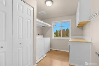 Large utility room with washer and dryer, shelfing, cabinets & storage.