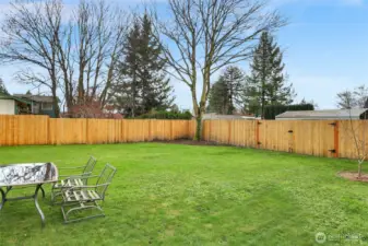 Fenced backyard with gated entry, gardens, fruit trees