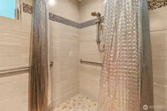 Floor-to-ceiling tile throughout the primary en suite.