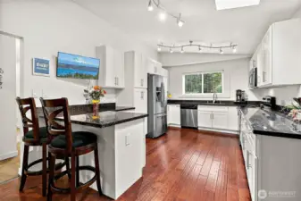 Updated kitchen is sleek and modern.  Plenty of space for too many cooks in the kitchen!
