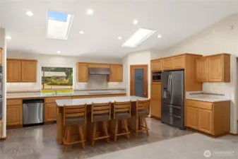 The kitchen is a chef's delight. The large island makes a great seating area or workspace. The pantry in the corner holds plenty of kitchen supplies. Kitchen features stainless steel appliances. There is a shelf for a microwave oven.