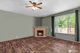 Living room from corner highlighting fireplace, large windows and backyard view