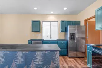 Updated kitchen with teal cabinets, newer stainless steel appliances, and walk-in pantry