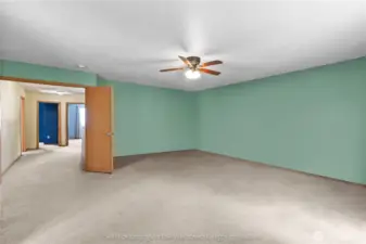 Huge primary bedroom with mint green walls and ceiling fan