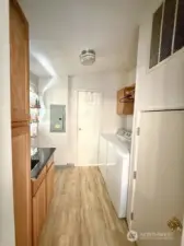 Private laundry room with storage space.