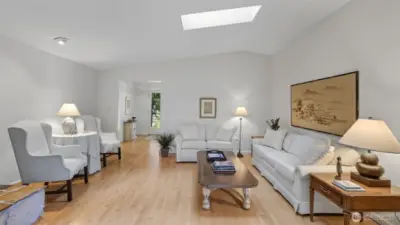 Sunlight streams through skylights and windows, enhancing the spacious living area.