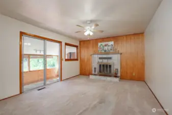 Family room includes a wood-burning fireplace and slider to the sunroom