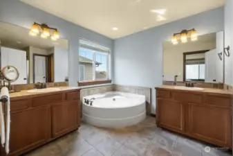 Large primary bath with separate vanities and soaking tub.