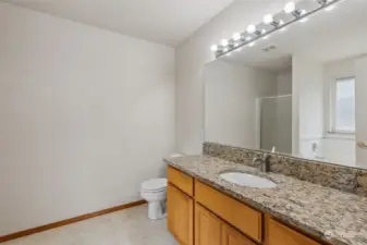 Primary bathroom with granite counters and backsplash