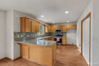 Kitchen with breakfast bar, granite countertops,  spacious double-door pantry.