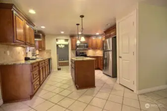 The elegantly designed traditional kitchen showcases cherry-stained raised panel cabinetry with top molding that enhances its classic charm. The bullnose granite countertops add a smooth, polished finish that complements the warmth of the cabinetry.