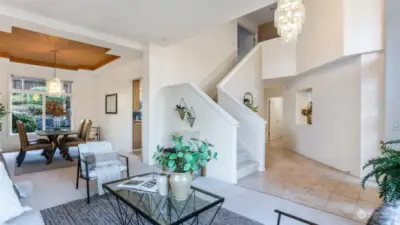 This spacious living room offers a clear sightline to the dining room, seamlessly connecting the spaces. The staircase leading to the second floor adds a touch of elegance and enhances the open-concept design, making it perfect for both everyday living and entertaining.