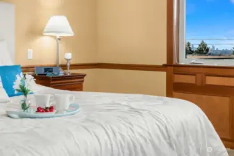 The elegant and relaxing primary suite offers a fireplace and inspiring sunsets, views of the Seattle skyline and Olympic Mountains on clear days.