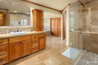 The large en suite spa-inspired bath with frame-less glass door double shower, Travertine tilework, heated floors, jetted tub, and huge cedar-lined walk-in closet.