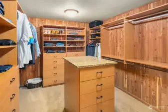 Oversized cedar-lined walk-in closet with   abundant built-in shelving and cabinet island.