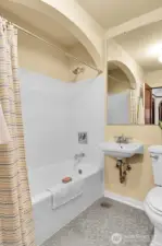 Full bath with tile surround and original tile floor.