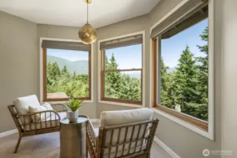 The primary suite is a serene retreat featuring a cozy sitting area, walk-in closet, spa-like bath and jaw-dropping views.
