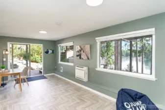 Downstairs bonus room with walls of windows and big Lake views. Slider to side patio and hot tub area