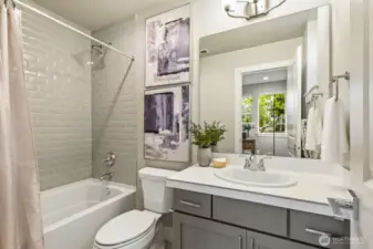 Main-floor ensuite bathroom w/ tub and shower and features upgraded tile including shower walls in tile all the way to the ceiling!