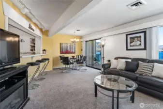 Living room looking towards the dining room and glass sliding doors leading to the lake view deck.