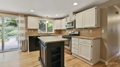 White cabinetry, subway tiled backsplash and more of the beautiful hardwoods that run throughout the home.