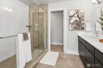 tiled double head shower with glass doors, quartz counters upgraded faucets, tiled floor