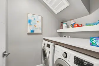 Laundry room with quartz counter and clothes rack above