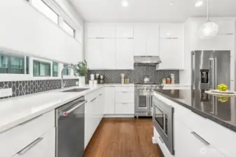 Rare Black quartzite island - a natural stone, not engineered for more durabliity and less maintenance. white quartzite counters in kitchen with top of the line tile surround.