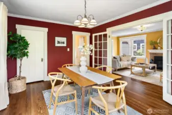 Dining room with closet. Refinished hardwood floors flow into the living room beyond the glass doors.