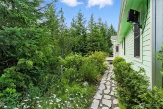 A charming pathway meanders gently through the garden, lined with lush greenery and vibrant flowers that create a serene and inviting atmosphere.