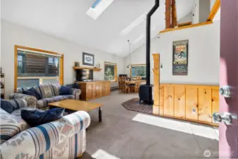 Bright, vaulted living room with wood accents and cozy fireplace.