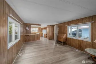 Looking from N end of living room back to kitchen and entrance door. Lots of large bright windows