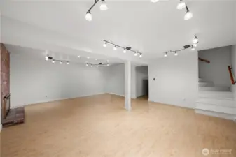 Lower level: bright rec room, backyard access, beautiful brick fireplace, high ceilings, lots of natural light & 1 bed/1 bath. The door leads out to the large fully fenced, level backyard w/ oversized patio.