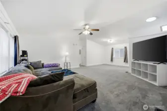 View from entry of living room, dining area and hallway to bedrooms, main bathroom and laundry