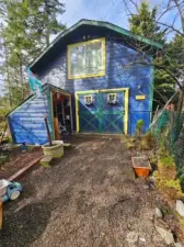 The garden shed is located outside the garage doors.