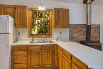 Double sink, refrigerator and wood cabinets.