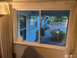 Family room looks out to garden, front entry, and driveway. Curtains can be closed for privacy.