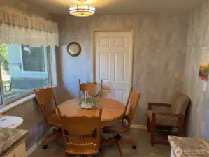 Small eating area in Kitchen looks out to front gardens yard and driveway.
