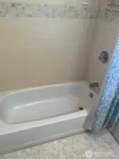 Soaking tube with Tile above in full bathroom near bedrooms.